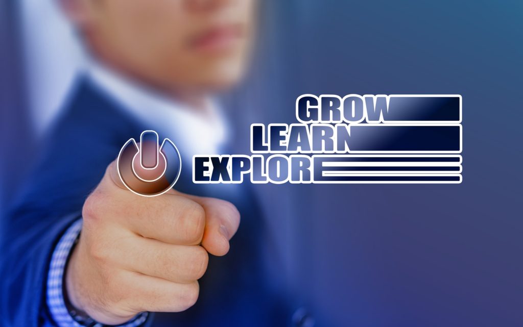 Photo of man pointing finger towards camera and works "Explore, Learn, Grow" stacked on one another.